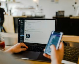 Un salarié au bureau devant son MacBook Pro et son smartphone