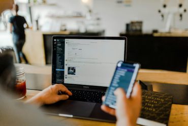 Un salarié au bureau devant son MacBook Pro et son smartphone