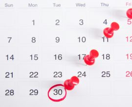 Calendrier avec des punaises rouges indiquant des dates importantes