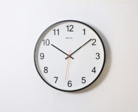 Horloge blanche fixée sur mur blanc
