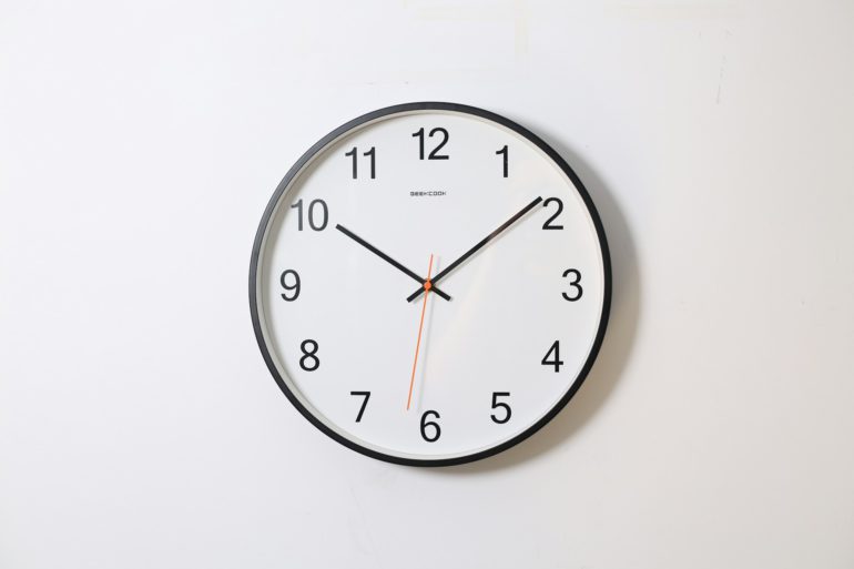 Horloge blanche fixée sur mur blanc